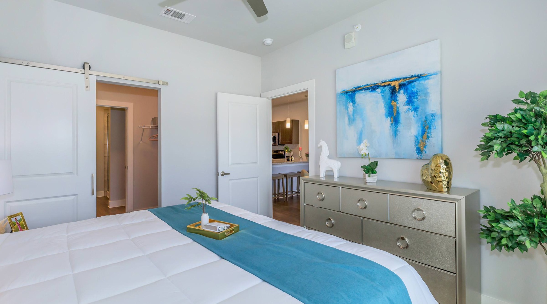 bedroom with ceiling fan plant and tables